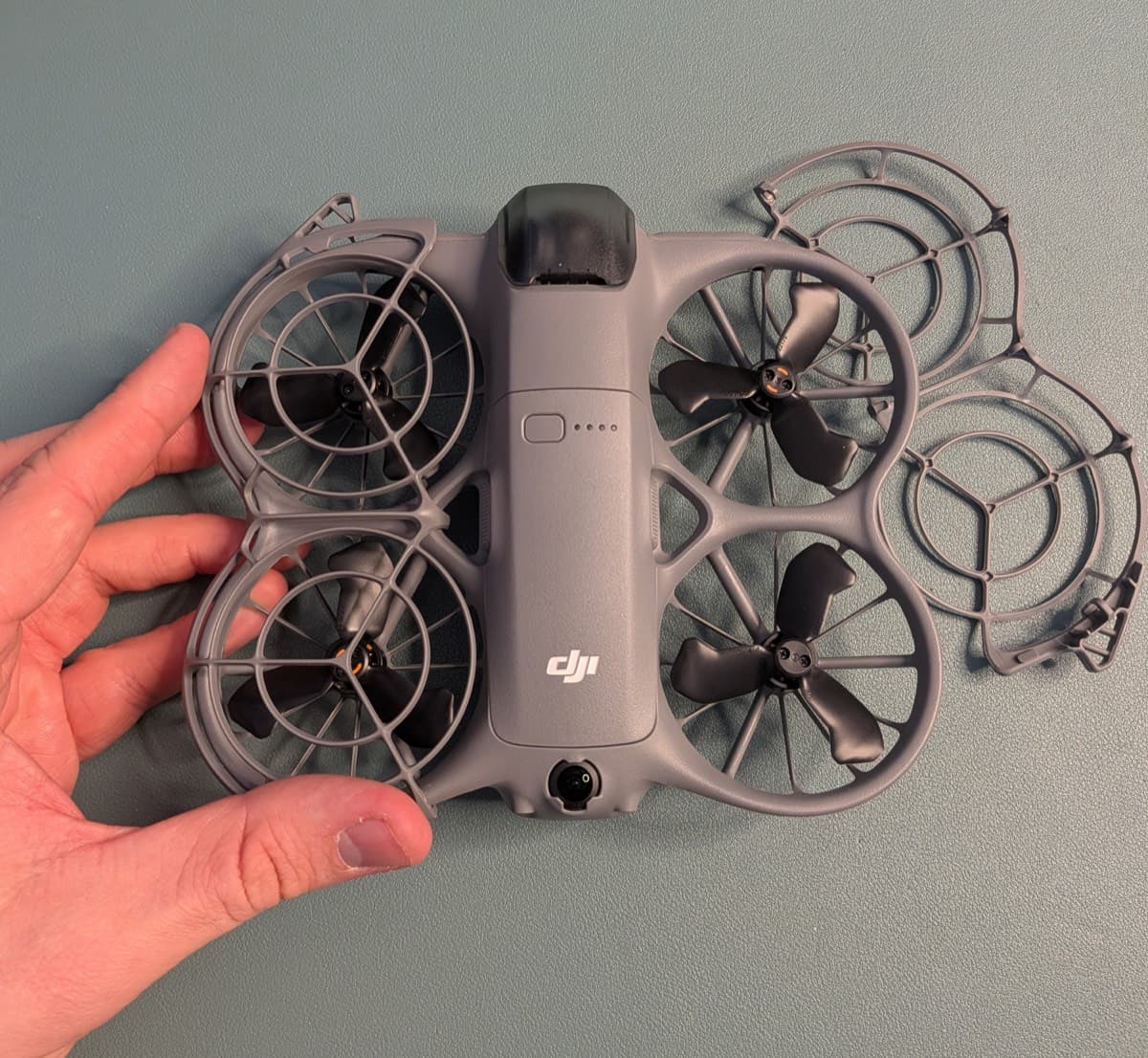 DJI Neo 2 with the propeller guards unclipped beside the drone before Step 1