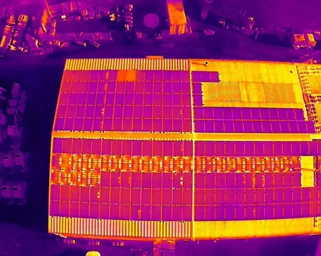 Large-scale aerial thermal imaging of solar panel installation showing comprehensive site analysis