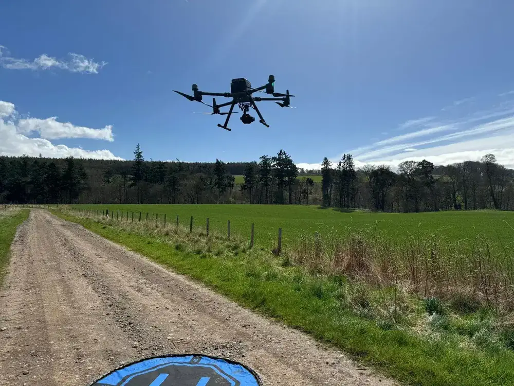 Drone operator working on a survey over uneven terrain