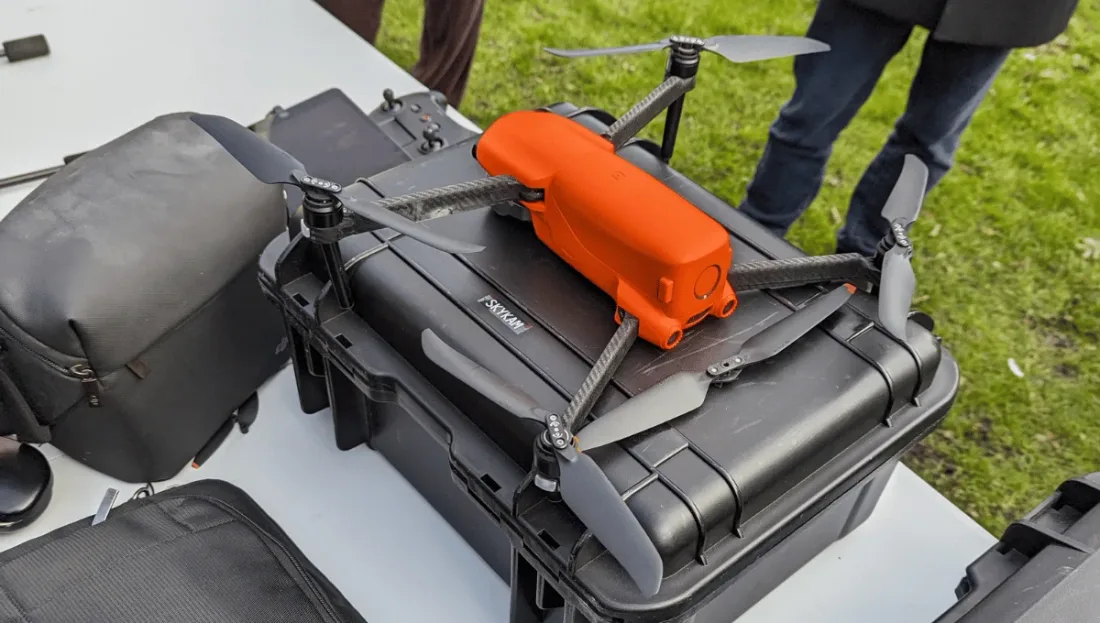 An orange Autel EVO folding drone unfolded on top of a black Pelican hard case at an outdoor job site