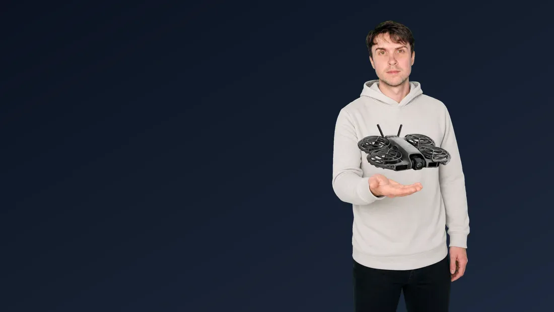 Peter Leslie holding out a flat palm with a DJI Neo 2 hovering just above it, its four propellers enclosed in full-coverage guards