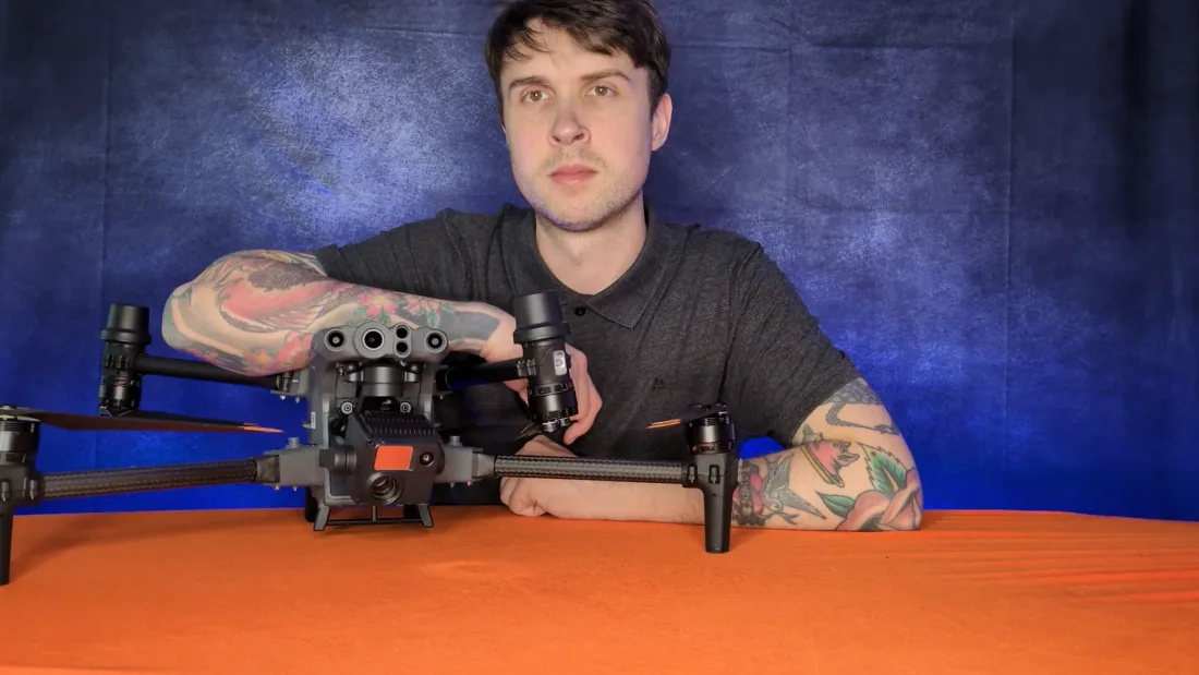 Peter Leslie behind a large professional survey drone with a multi-sensor camera head, dwarfing the folding consumer drones elsewhere in this guide