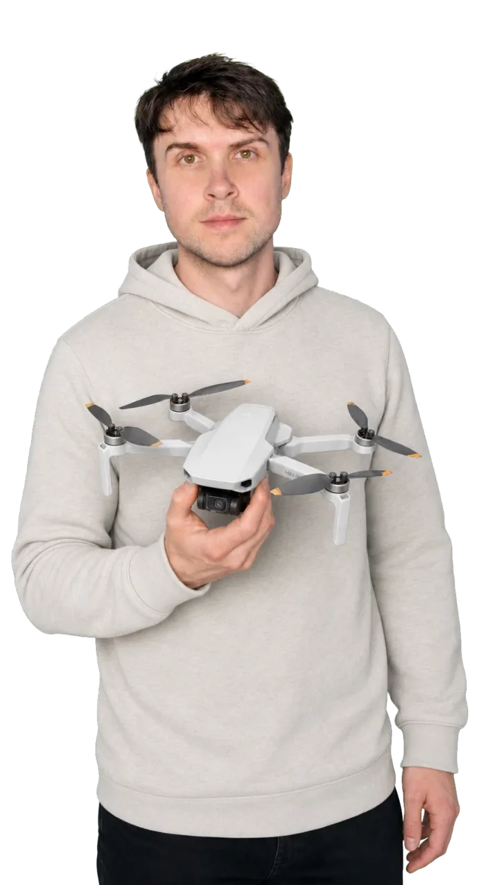 Peter Leslie holding a small folding sub-250-gram DJI drone in one hand, at chest height