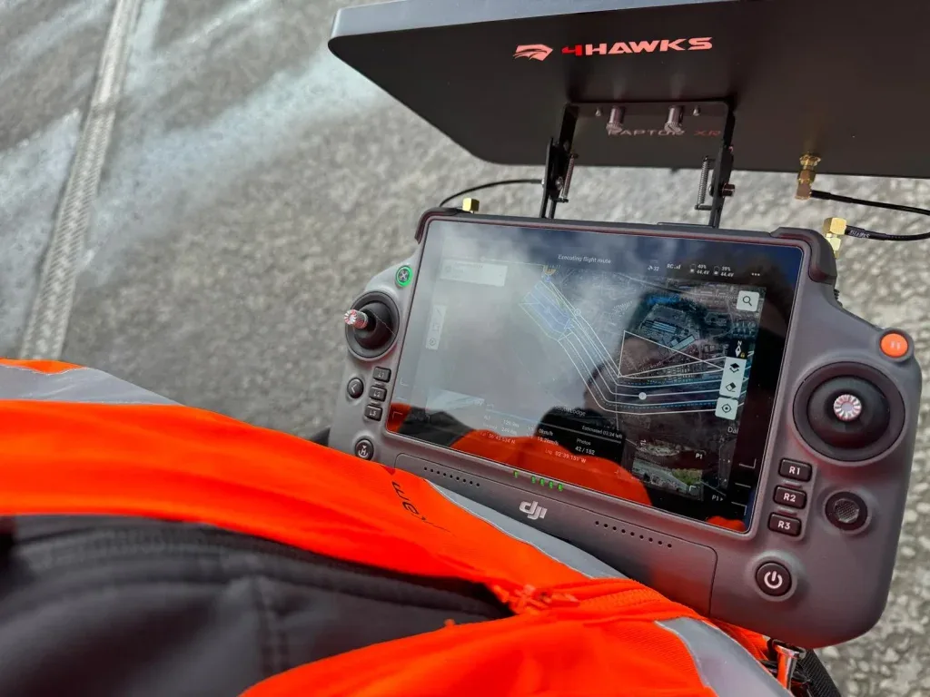 A DJI RC Pro controller with a 4Hawks Raptor XR directional antenna array clamped to the top, showing a survey flight route on screen