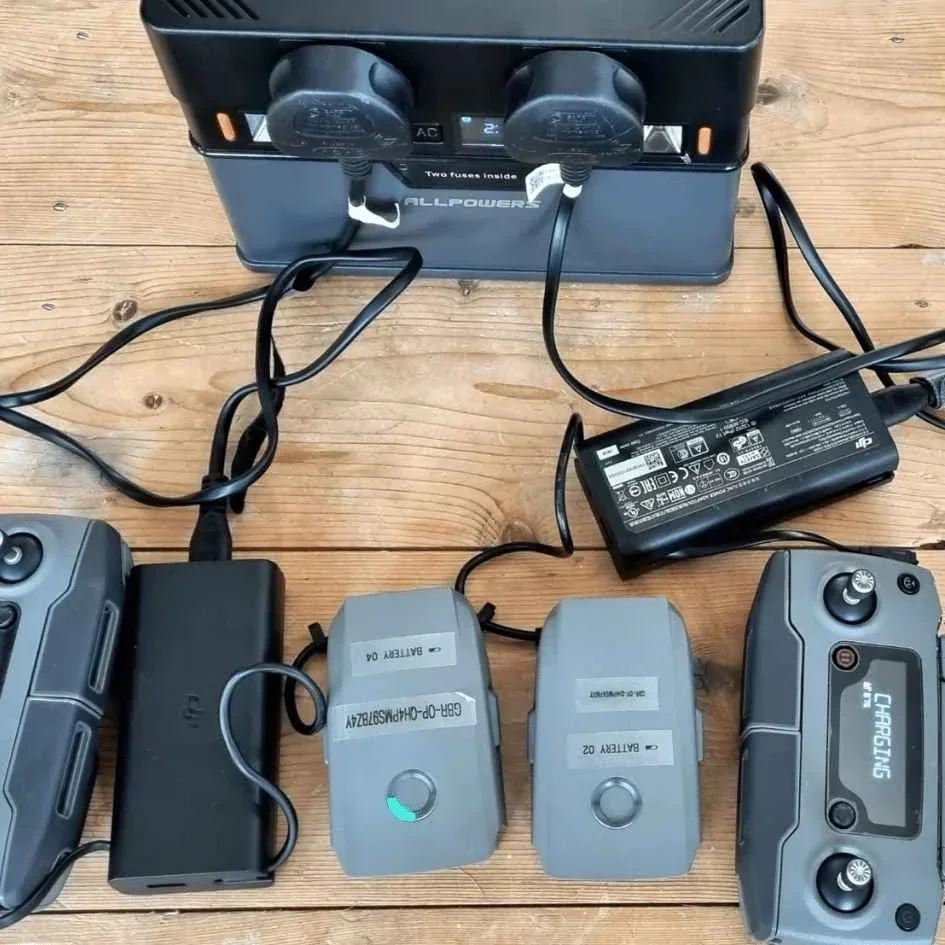 Drone battery connected to a charger on a workbench