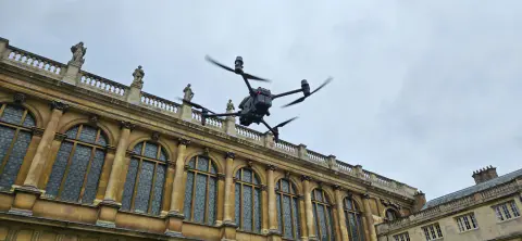 Drone inspecting a historic stone university building