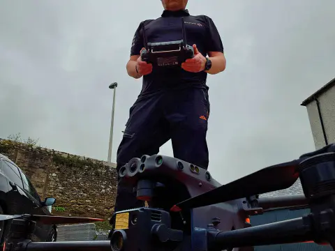 Drone pilot holding DJI smart controller over Matrice airframe
