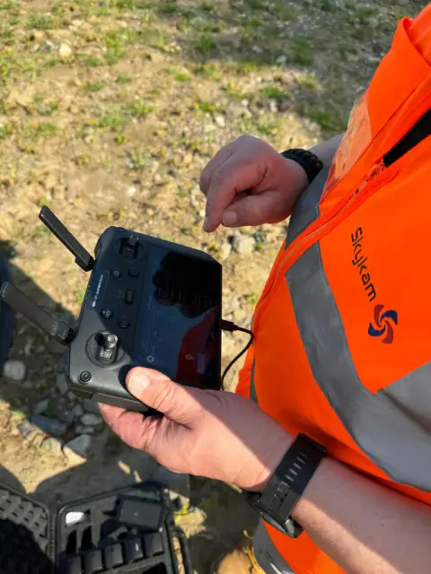 Drone pilot operating DJI RC controller on site